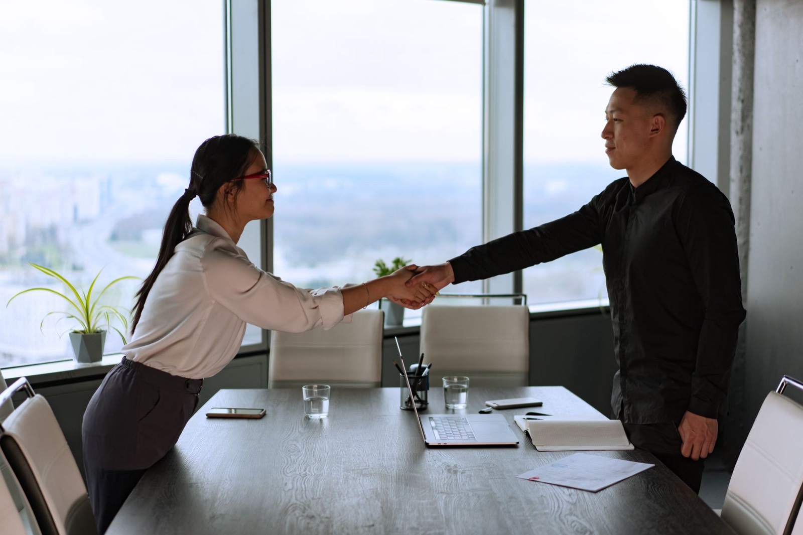 Poignée de main entre une responsable RH et un nouveau salarié le jour de son arrivée au bureau