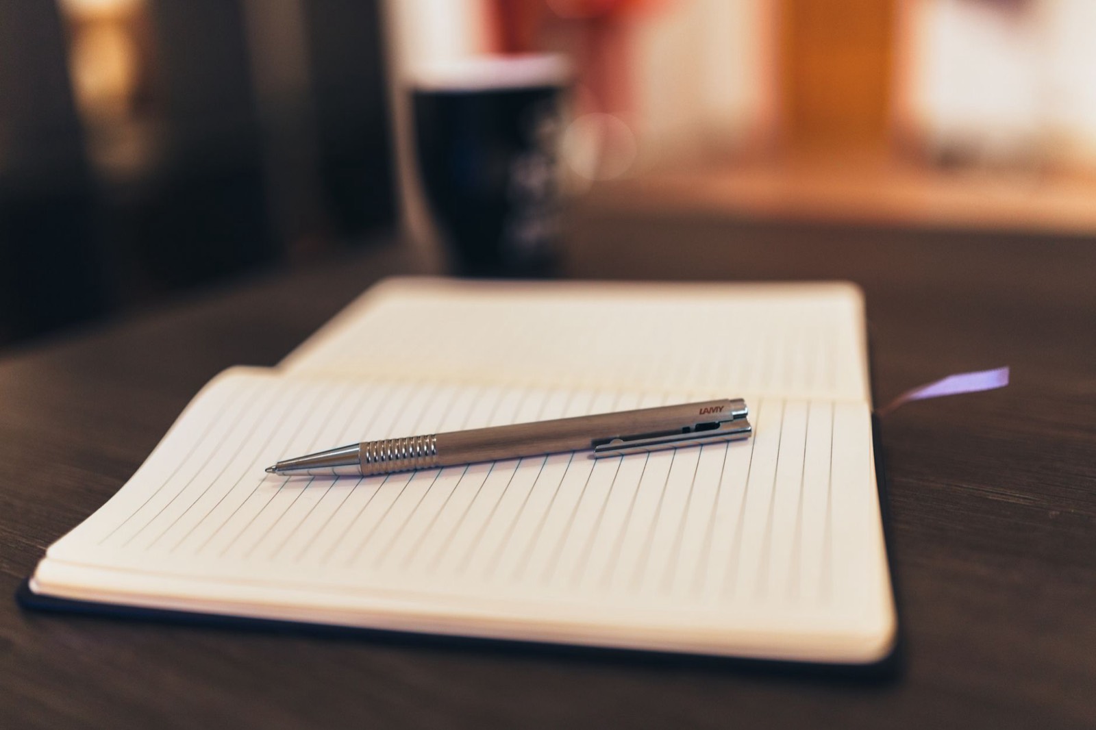 Carnet, mug et stylo personnalisés posés sur un bureau pour un kit de bienvenue