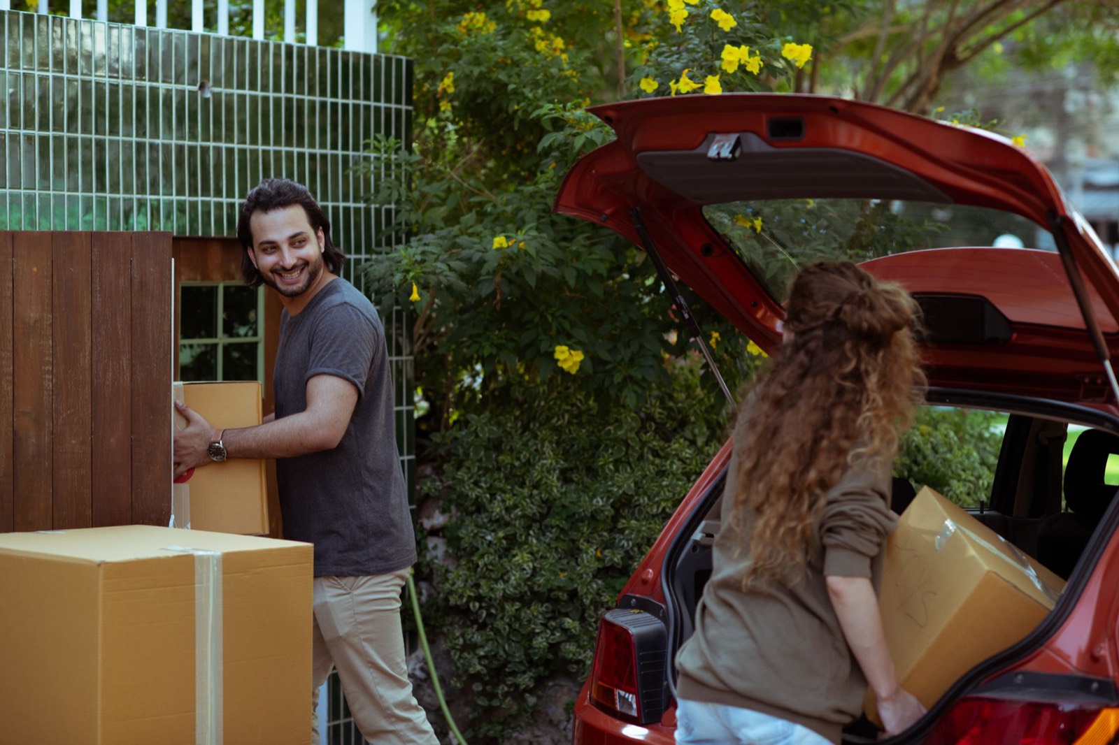 Cartons de déménagement posés près d'une voiture lors d'une mutation professionnelle